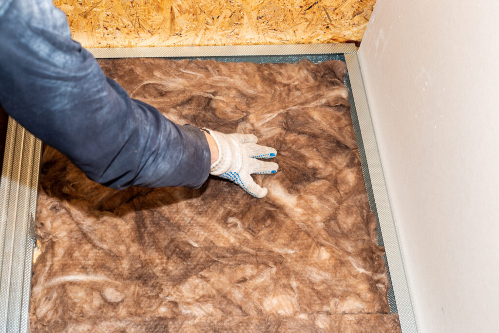 Шумоизолация - видове и съвети 8 worker insulates walls with mineral wool further cladding with plasterboard thermal insulation sound insulation house 1