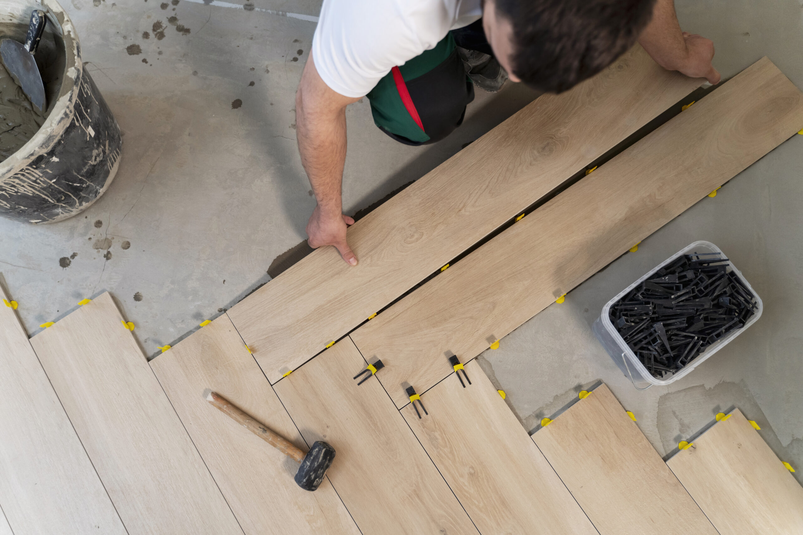 Полагане на ламинат: Инструменти и често допускани грешки 6 top view man tiling floor 1 scaled